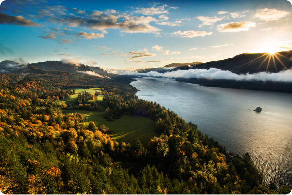 Ethereal lit scene of the Columbia River Gorge with deep blues and golden light.