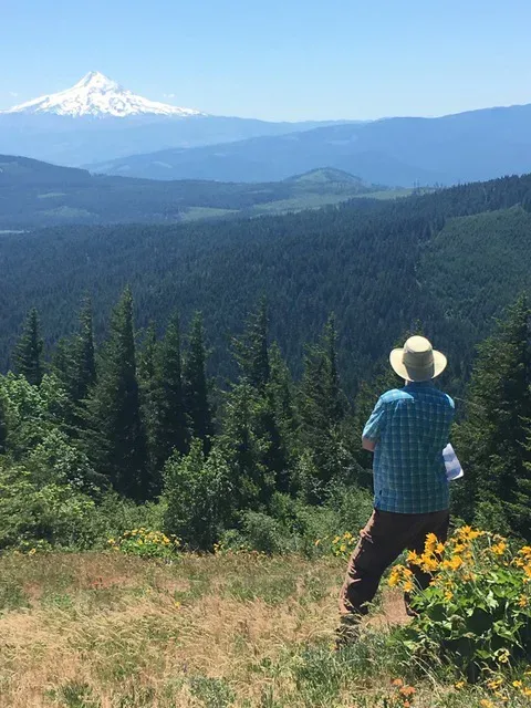 The author takes in the view from Nestor Peak. The photo shows Mt. Hood in the distance and the Whistling Ridge project site in the middle ground. Photo by Sharon Ross.