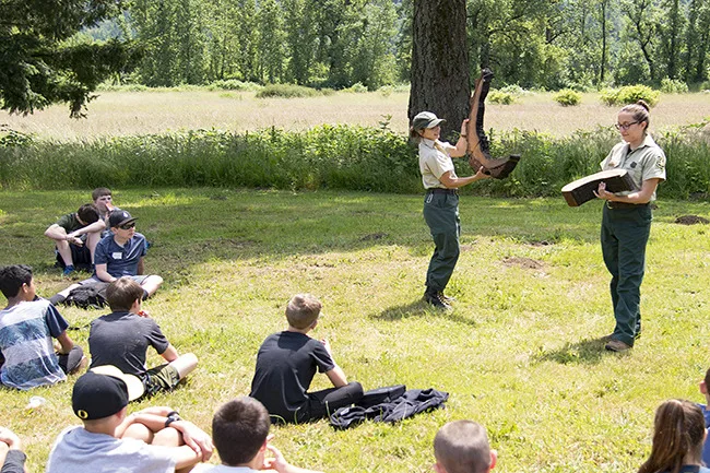 U.S. Forest Service rangers show Washougal sixth-graders the effects of fire on bark of different tree species. (photographer: Brandon Davis)