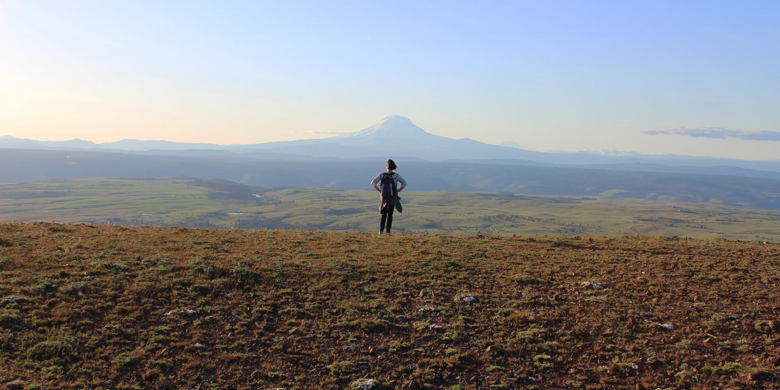 Facing away from the Columbia River, a hiker on top of Stacker Butte takes in the view of Mt. Adams. Photo by Stan Hall.