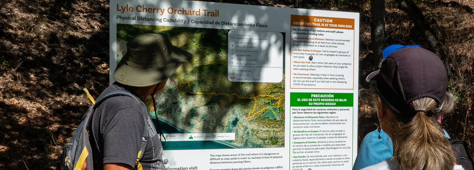 New bilingual, physical-distancing sign at Friends' Lyle Cherry Orchard land trust preserve. (photographer: Richard Kolbell)