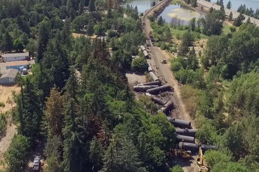 Video image shows an aerial view of crumpled oil tankers lying beside the railroad tracks after a fiery train derailment on June 3 in Mosier, OR. (photographer: Brent Foster via Associated Press)
